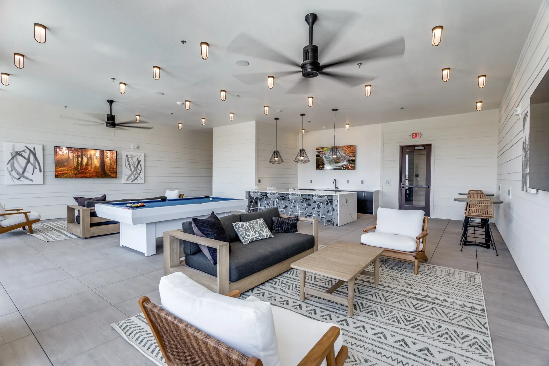 Community lounge area with a pool table, bar, seating, and decor.