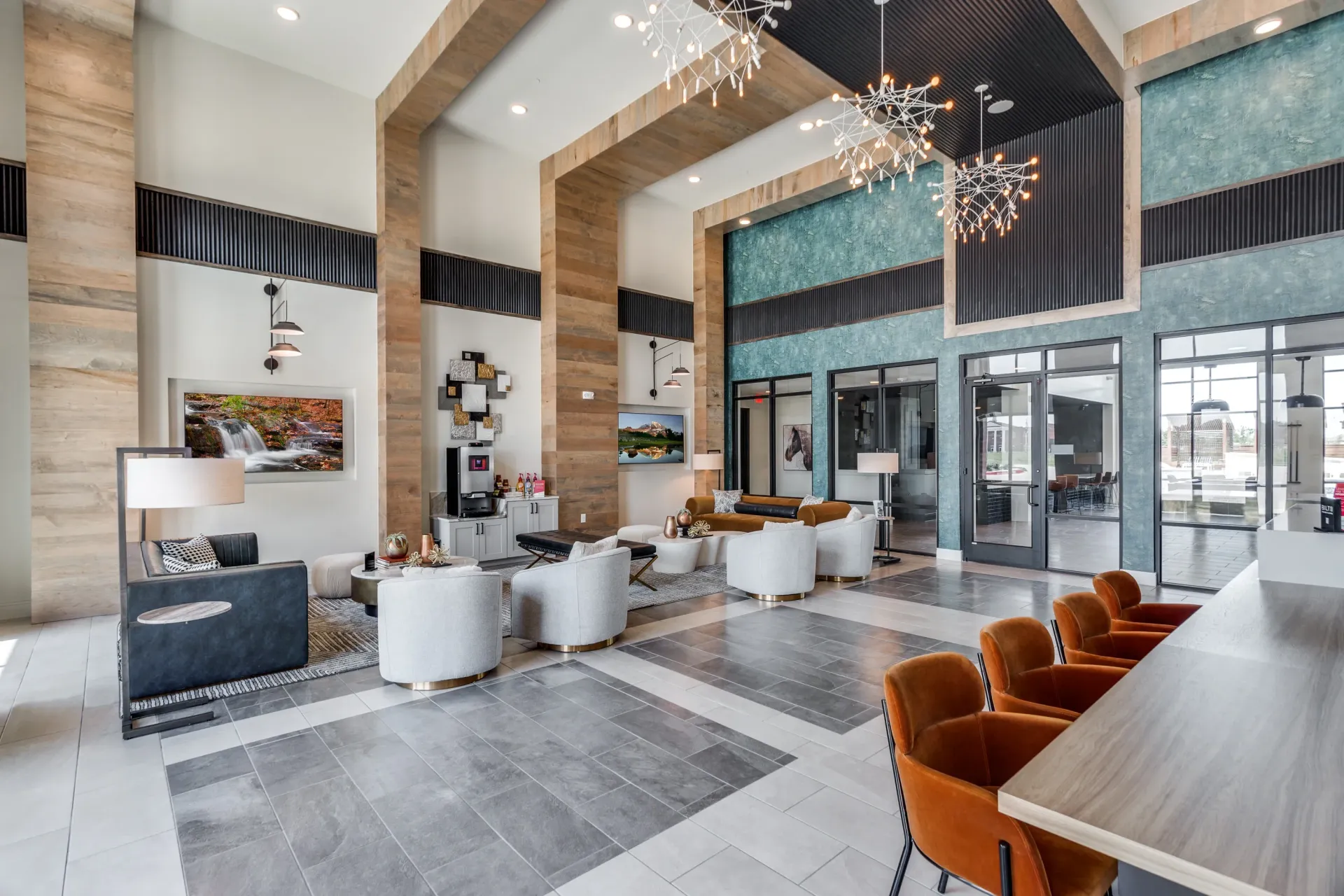Spacious and modern lobby with comfortable seating, decorative lighting, and a coffee station.