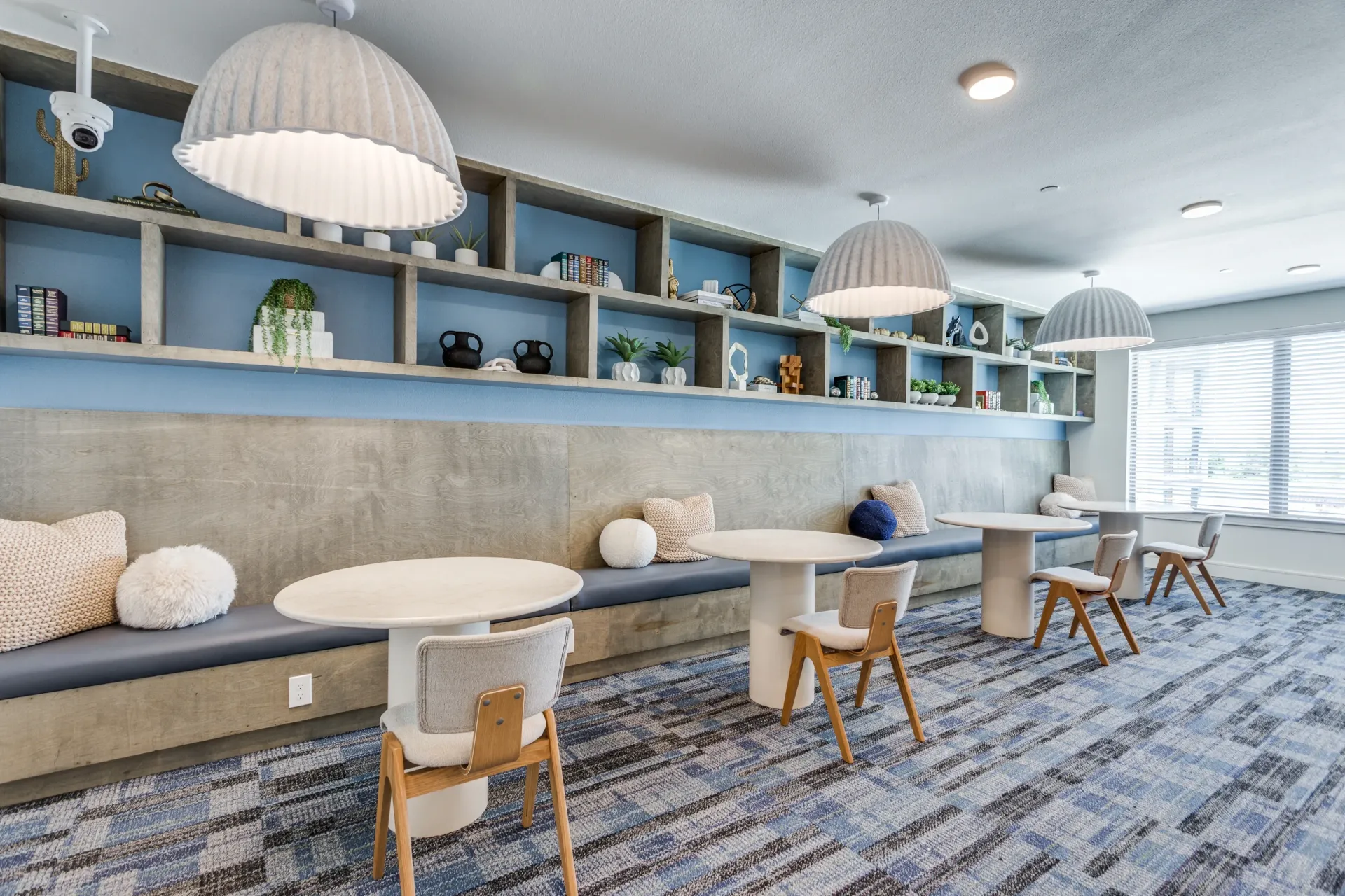 Communal seating area with tables and chairs in a modern lounge.