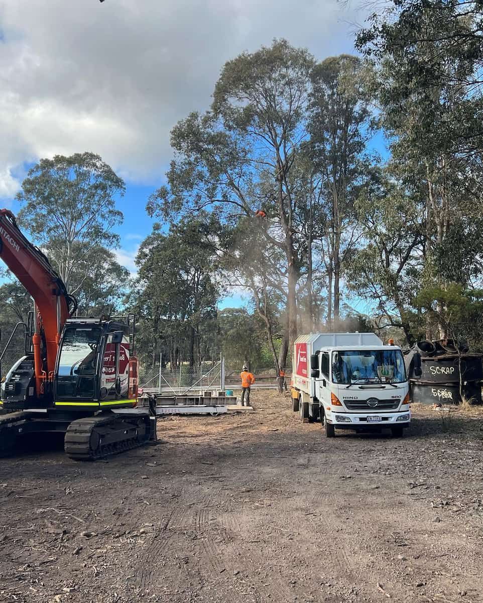 Construction Site With Excavator, White Truck, and Worker — Burnett Trees in Wollongong, NSW