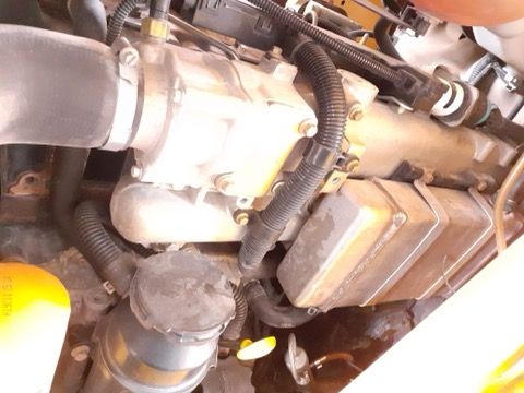 Car engine with a supercharger and various hoses and components.