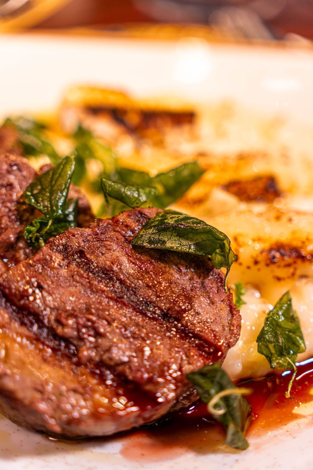 Close-up de um bife grelhado com ervas e queijo derretido num prato