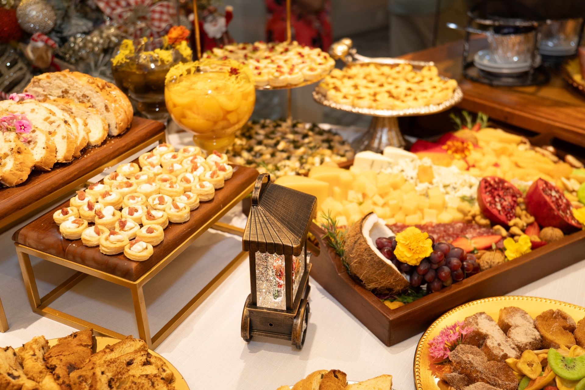 Mesa de buffet com uma variedade de doces e pratos de frutas em um salão de jantar de restaurante.