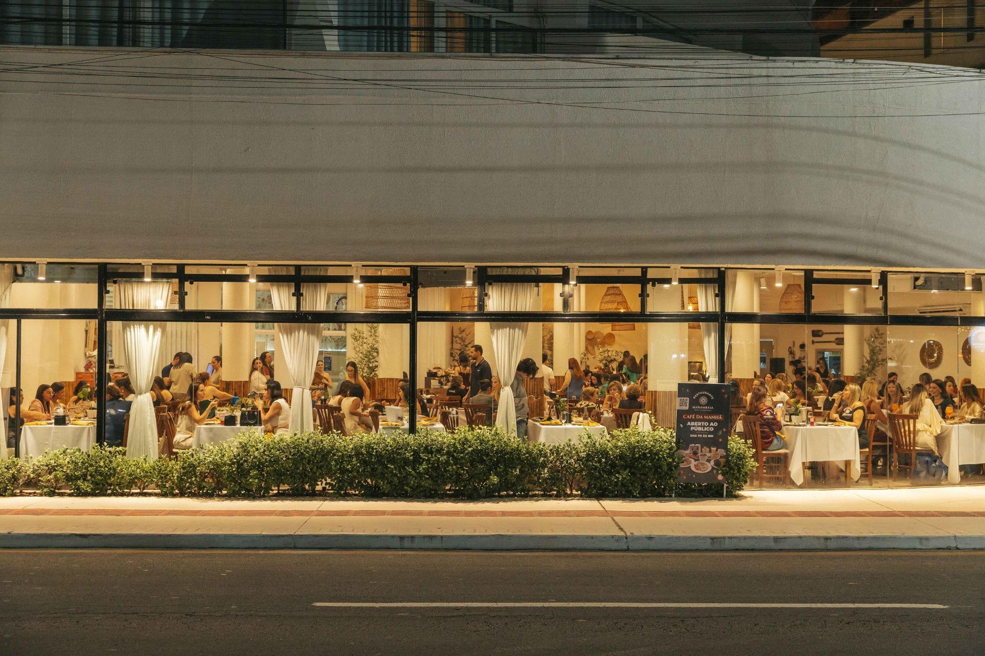 Buffet com uma variedade de pratos dispostos em um longo balcão em um restaurante com iluminação aconchegante.