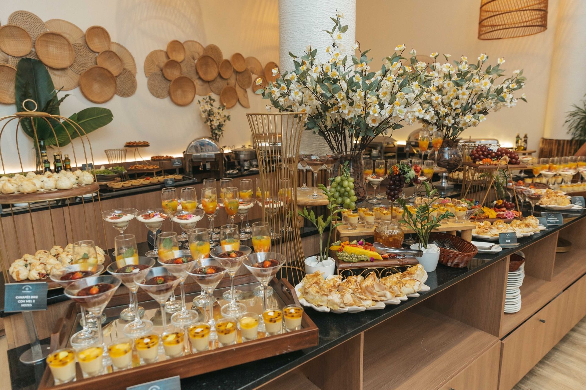 Buffet com uma variedade de pratos dispostos em um longo balcão em um restaurante com iluminação aconchegante.