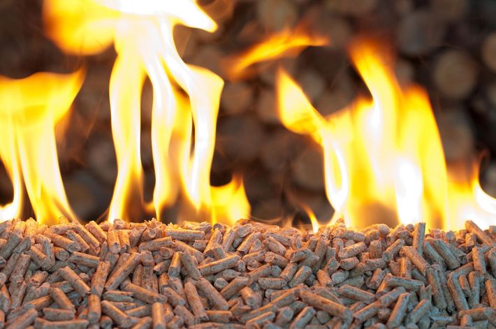 Fiamme che bruciano sopra un mucchio di pellet di legno