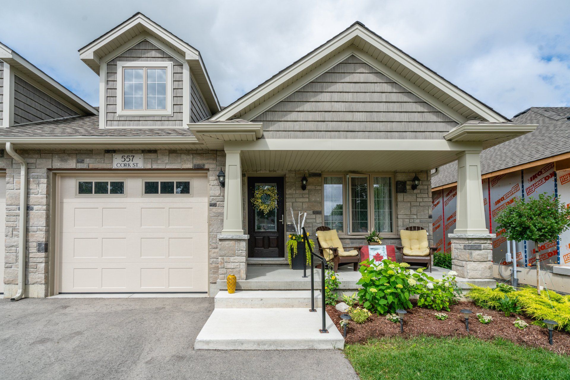 A small house with a large garage and a porch.