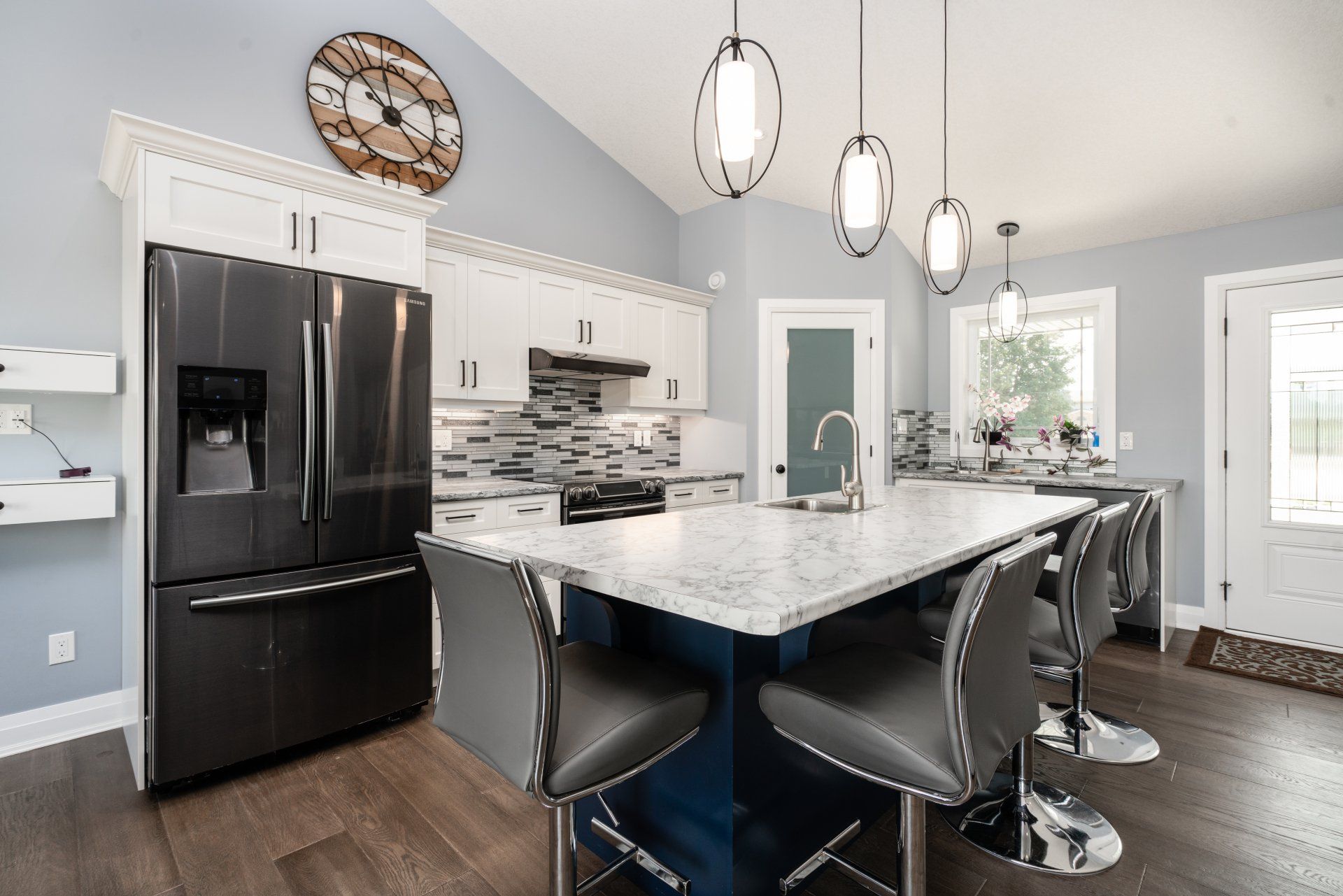 A kitchen with a large island and a clock on the wall.