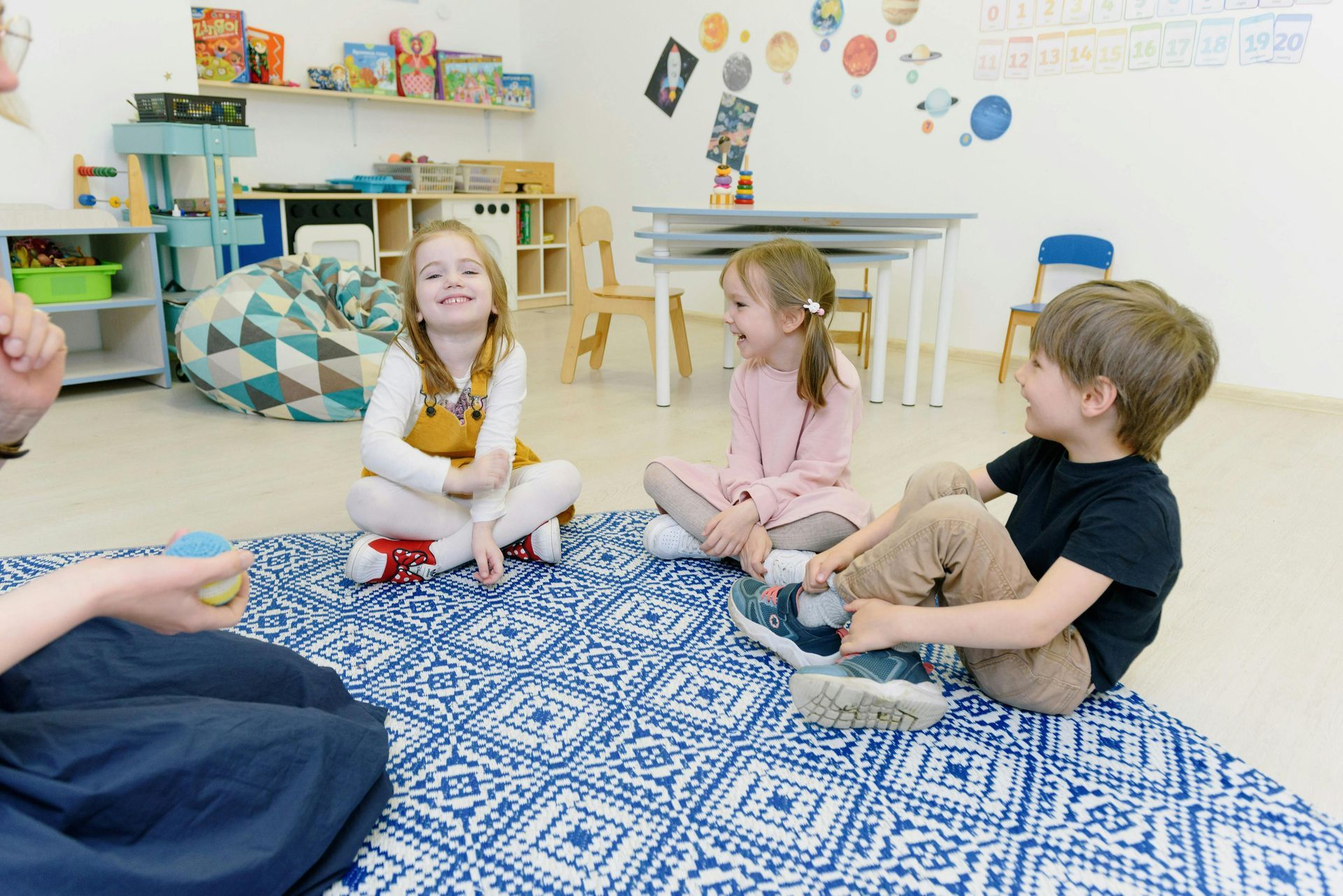 Teacher showing a craft to a child in a classroom, both smiling