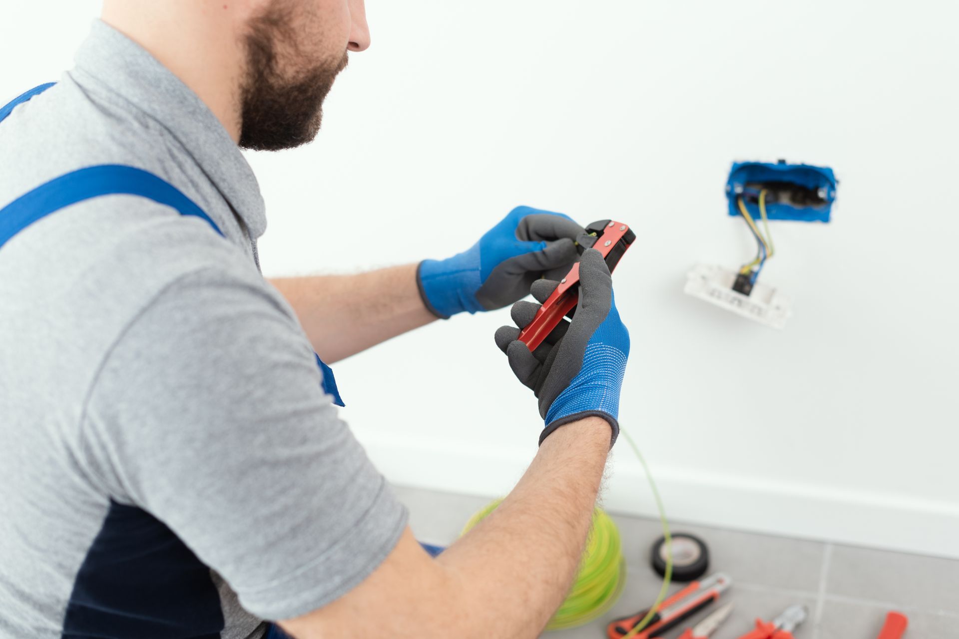 A partial view of a professional Electrician working on an electrical power point.