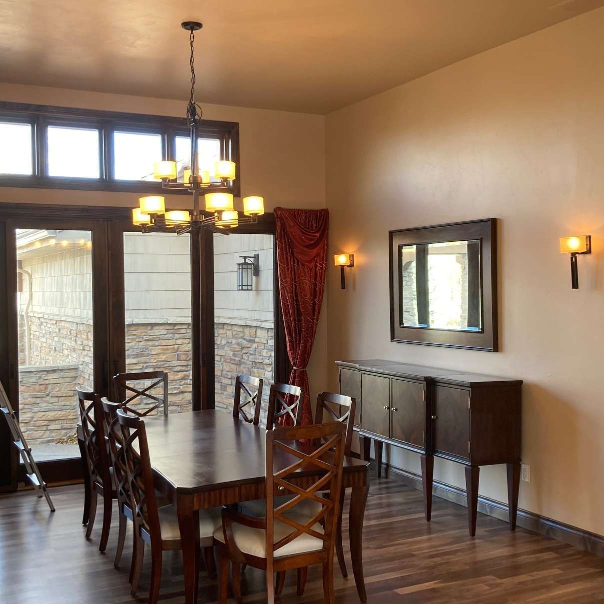 Dining room with dark wood furniture, a chandelier, and a large window.
