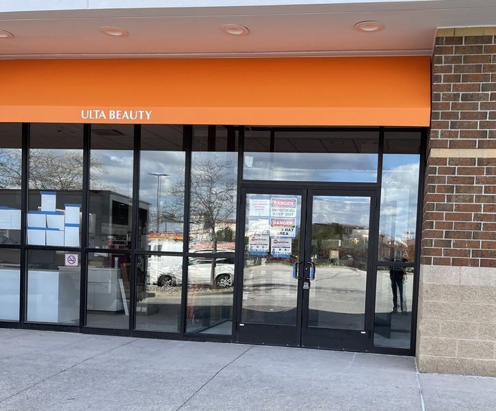 Storefront entrance with orange awning and glass doors at LITA Beauty.