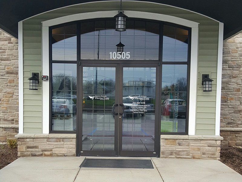 Front entrance with glass double doors, stone base, and address 10505 above the doorway.