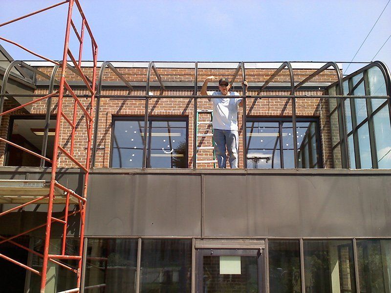 Person on scaffolding working on the roof of a modern building