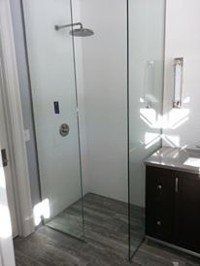 Small modern bathroom shower with glass door and dark vanity