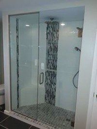 Modern glass shower stall with tiled floor and wall-mounted showerhead