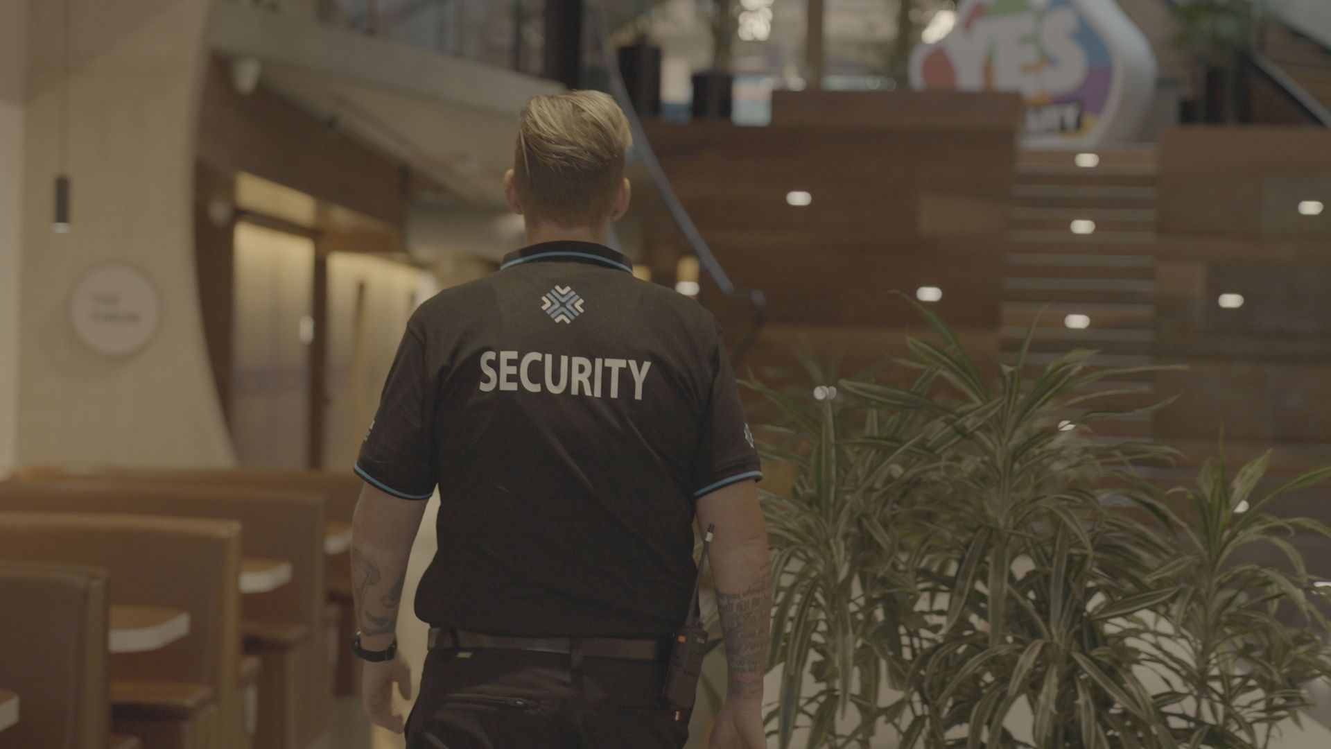 A security guard is walking down a staircase in a building.