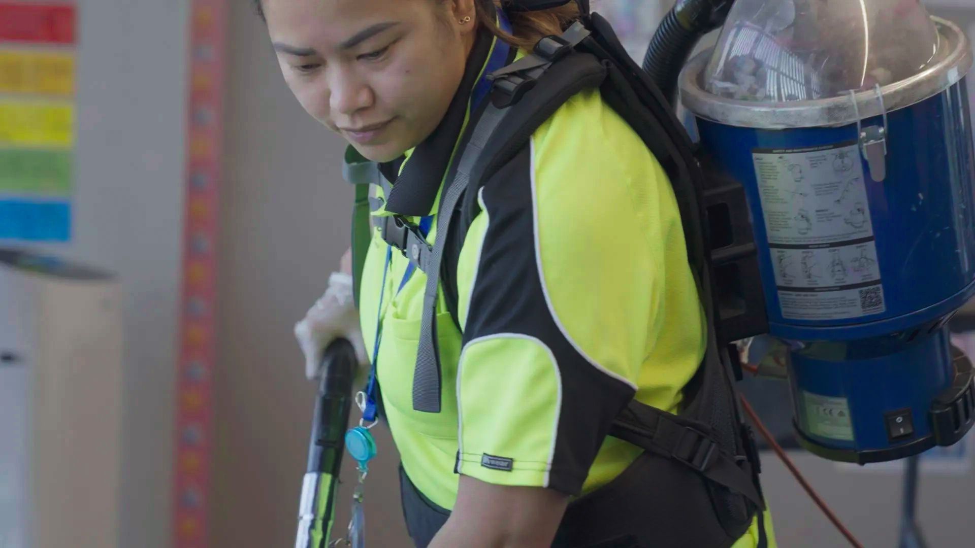 A woman is cleaning a room with a vacuum cleaner.
