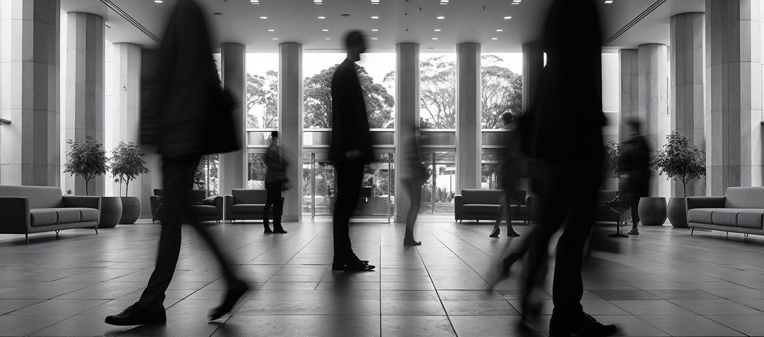 A group of people are walking in a lobby in a black and white photo.