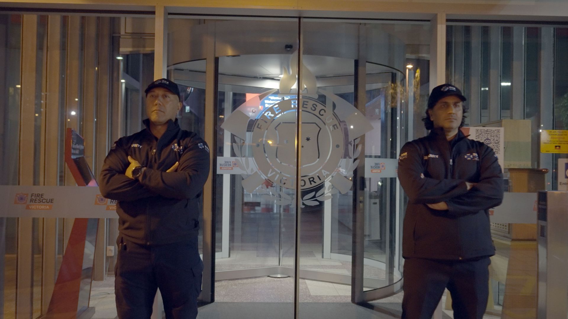 Two SSX group security guards are standing in front of a glass door.