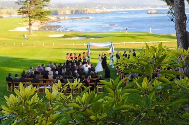 A wedding ceremony is taking place on a lush green field.