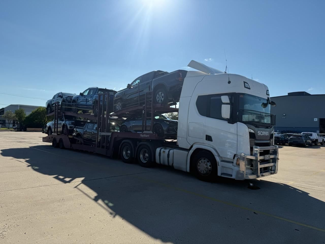 White Car Carrier Truck Transporting Several Vehicles on a Sunny Day — Alfie's Towing in Bentley Park, QLD
