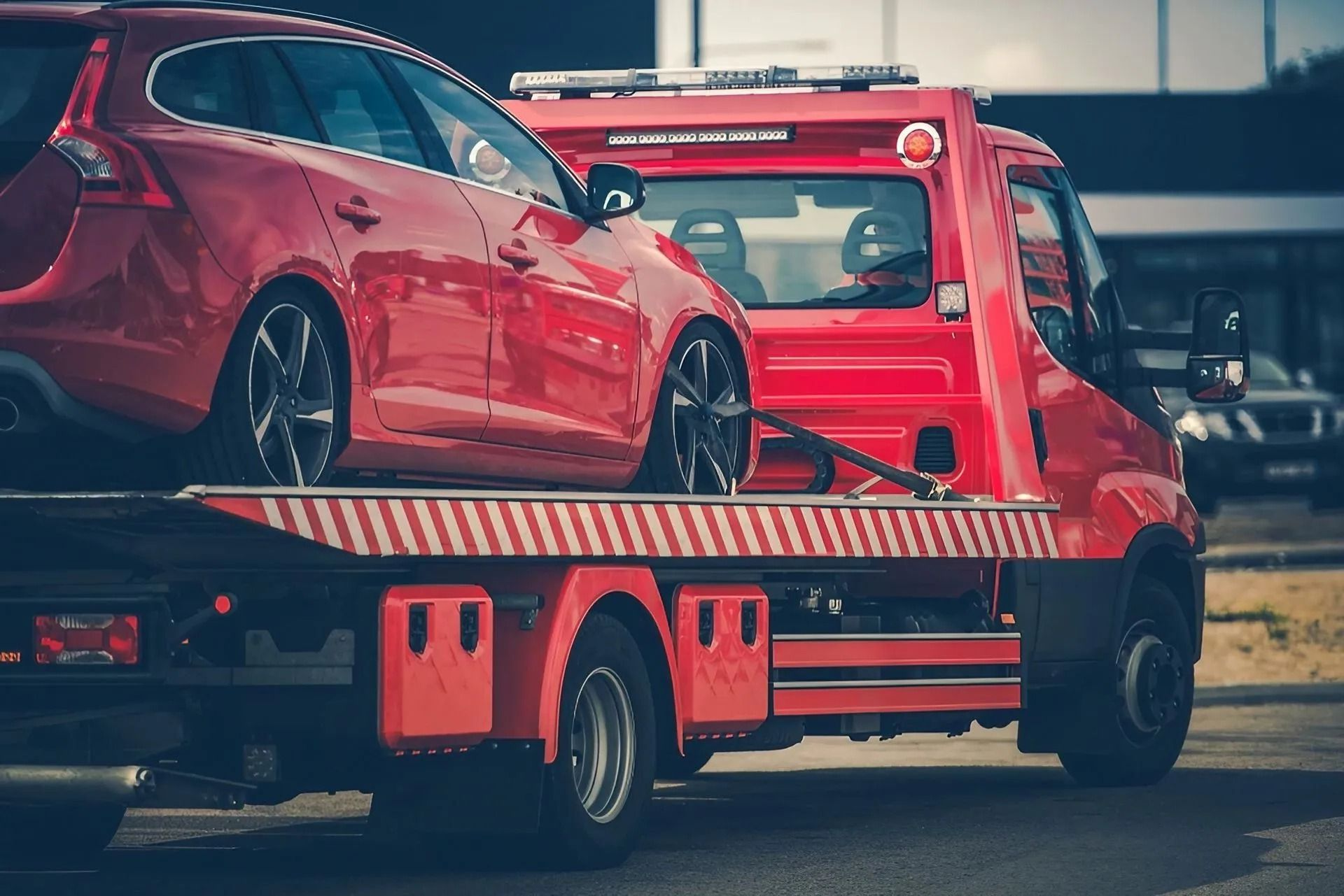 Red Tow Truck Carrying a Red Car on a Flatbed; Outdoors on a Street — Alfie's Towing in Bamaga, QLD