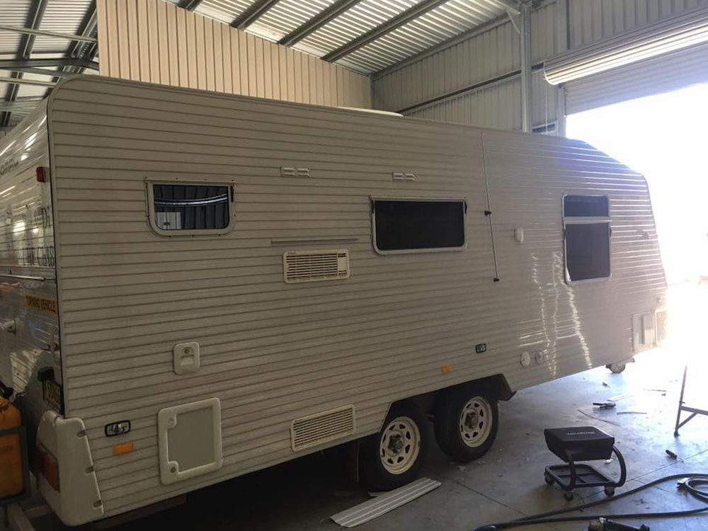 A Caravan Is Sitting In A Garage Under A Roof — Posties Caravans Boats Small Engines Inverell In Inverell, NSW