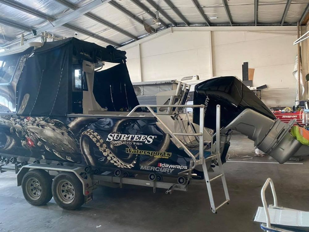 A Boat Is Sitting On A Trailer In A Garage — Posties Caravans Boats Small Engines Inverell In Inverell, NSW