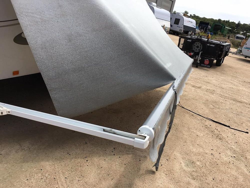 A White Awning Is Sitting On The Ground Next To A Trailer — Posties Caravans Boats Small Engines Inverell In Moree, NSW