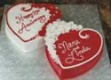 Two hearts shaped cakes are sitting on top of each other on a table.