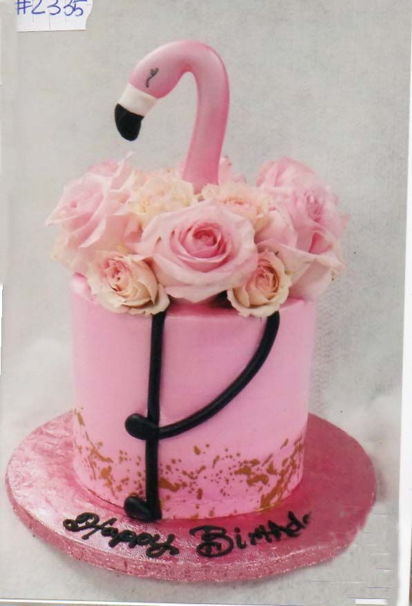 A pink birthday cake with a flamingo and roses