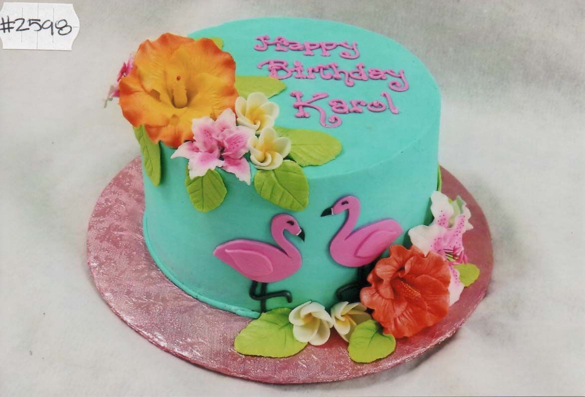 A birthday cake with flamingos and flowers on it