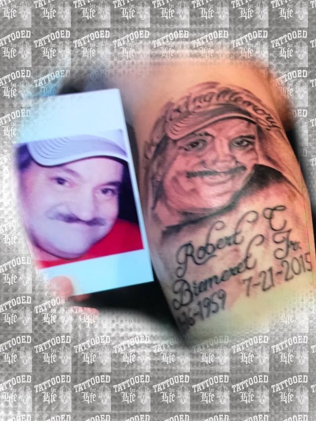 A man has a tattoo of a man 's face on his arm.