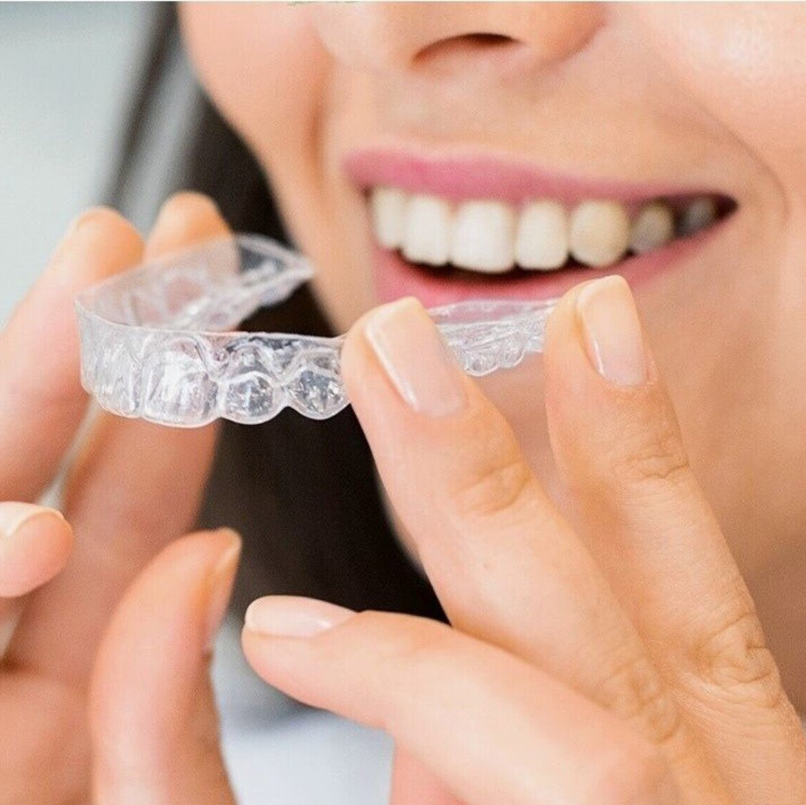 woman putting on invisalign aligner