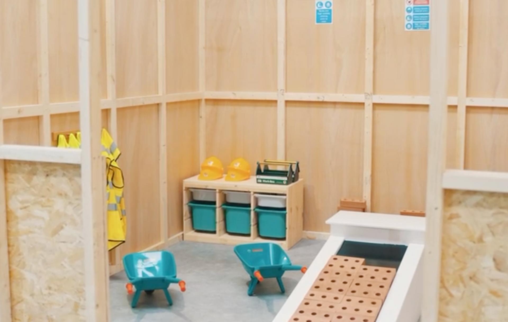 A room with wooden walls and toys on the floor.
