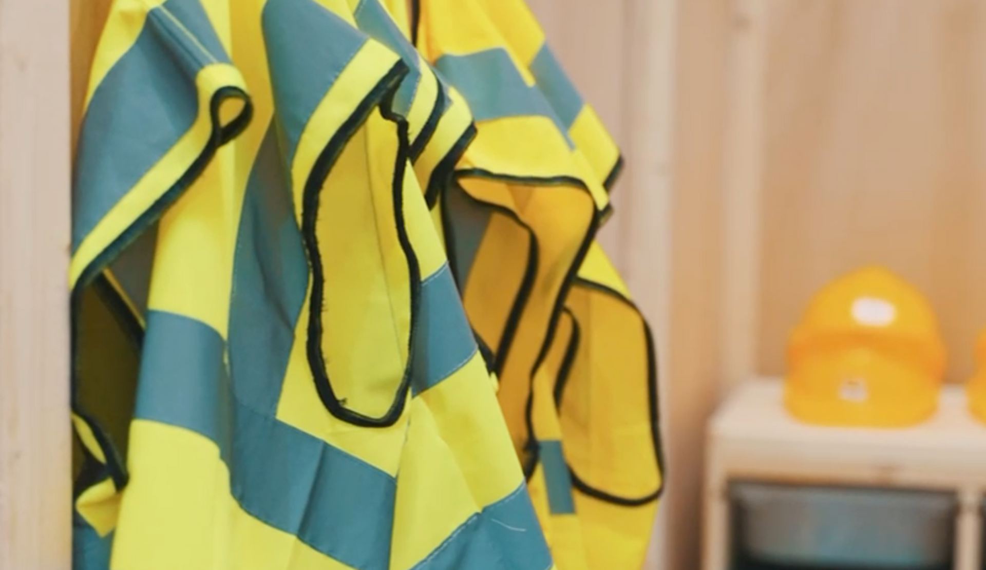 A yellow and blue towel is hanging on a wooden wall.