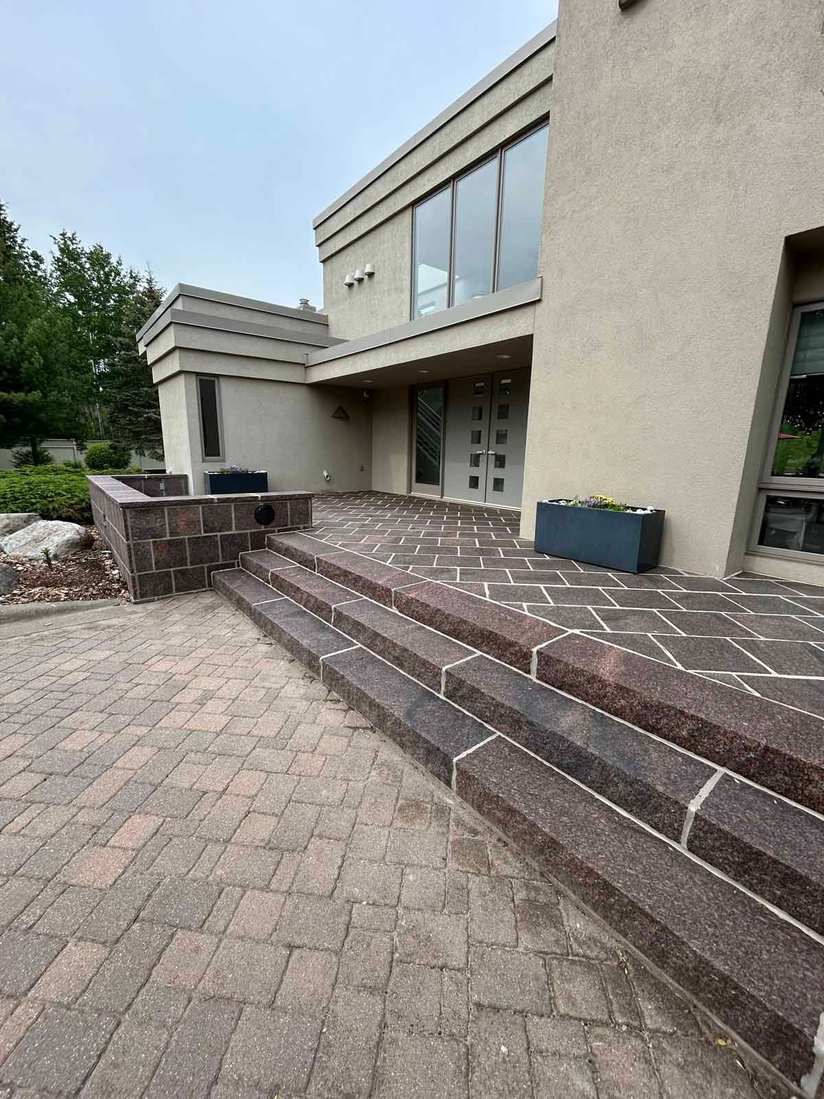 Exterior view of a house with stone steps and walkway leading to the front door.