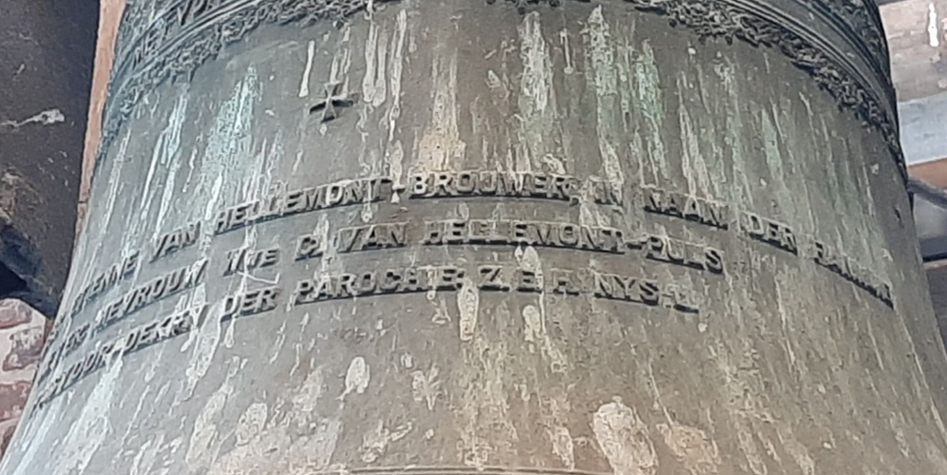 PETER: DE HEER ETIENNE VAN HELLEMONT, BROUWER, IN NAAM DER FAMILIE METER: MEVROUW WWE C. VAN HELLEMONT-PULS PASTOOR-DEKEN DER PAROCHIE Z.E.H. NYS Opschrift kerkklok