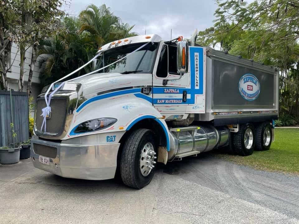 A White And Blue Dump Truck Is Parked In A Driveway — Zappala Raw Materials Pty Ltd In Mission Beach, QLD