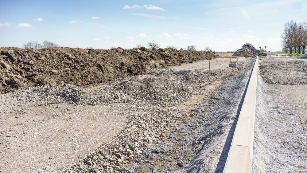 A Large Pile Of Dirt Is Sitting Next To A Road — Zappala Raw Materials Pty Ltd In Gordonvale, QLD