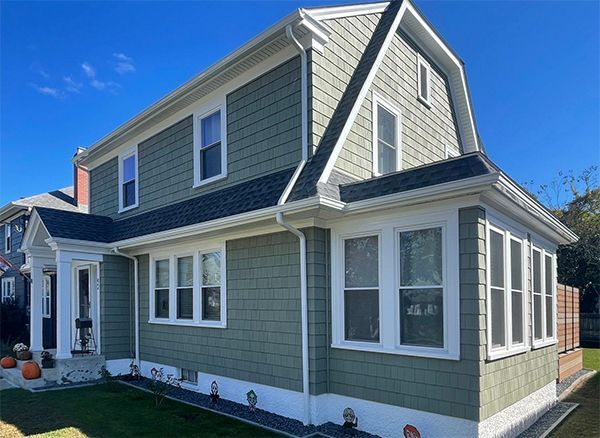 Gray two-story house with white trim and many windows on a sunny day