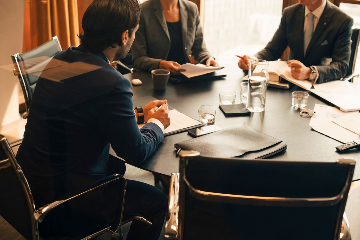 A group of people are sitting around a table having a meeting.