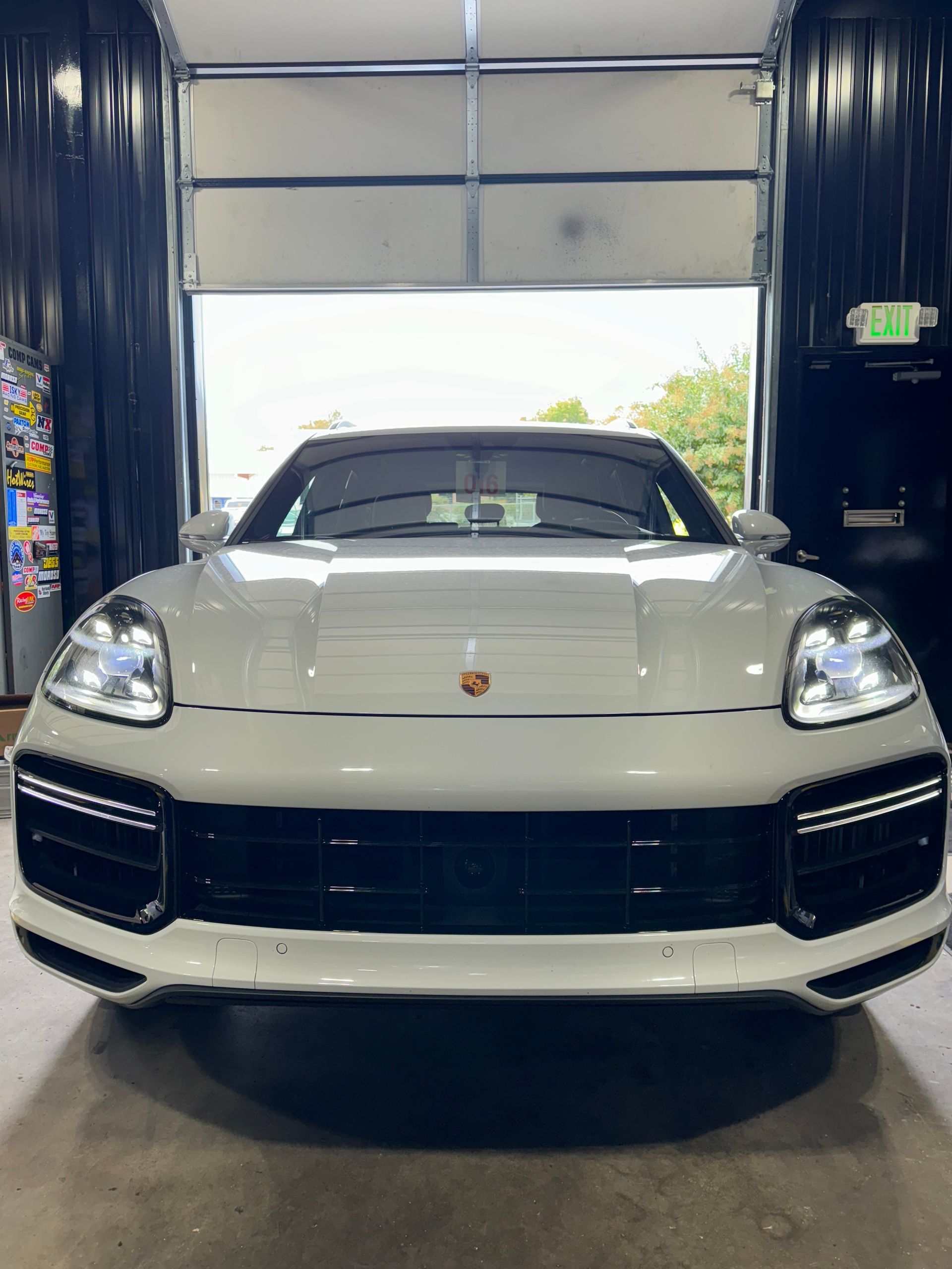 White Porsche SUV parked in a car wash bay, front view | Pro Import Automotive Service and Repair