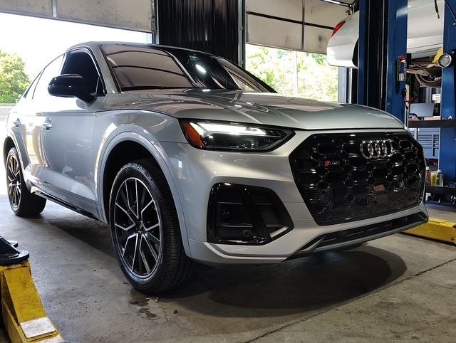 Silver Audi SUV in a service bay on a lift, front view | Pro Import Automotive Service and Repair