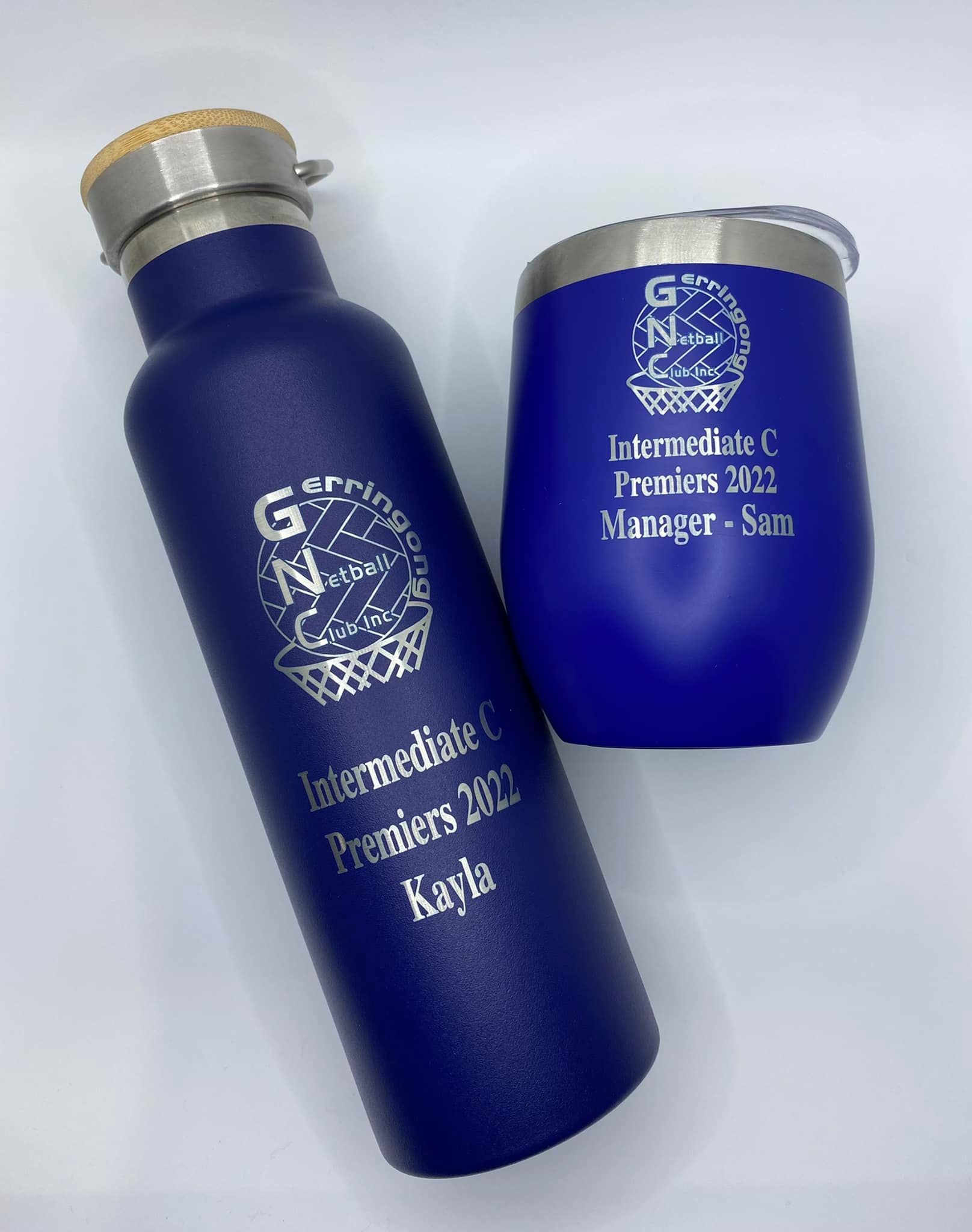 A Blue Water Bottle and a Wine Glass Are Sitting Next to Each Other on a Table — Jimani Trophies & Engraving In Dapto, NSW