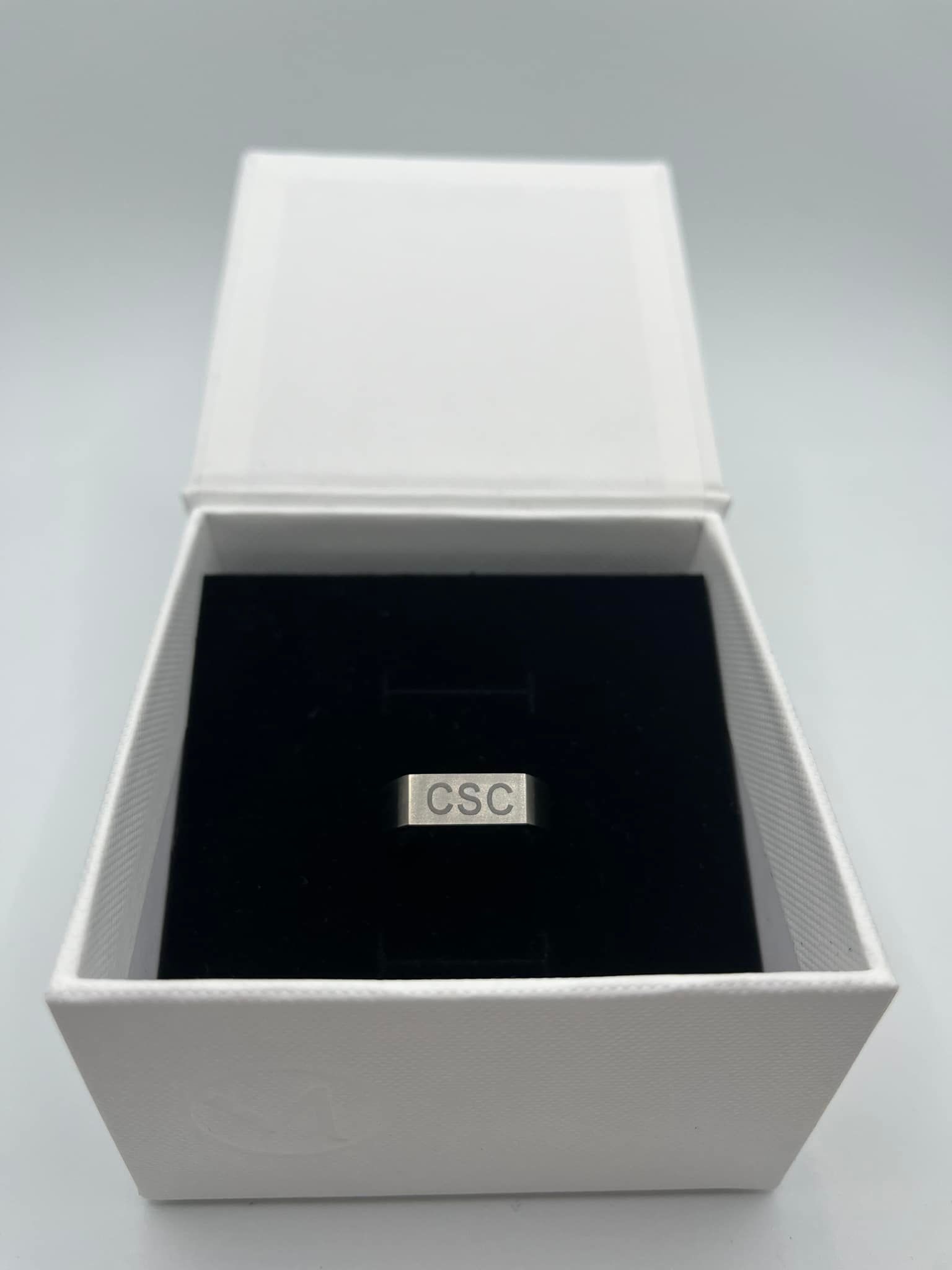 A Ring is Sitting Inside of a White Box — Jimani Trophies & Engraving In Dapto, NSW