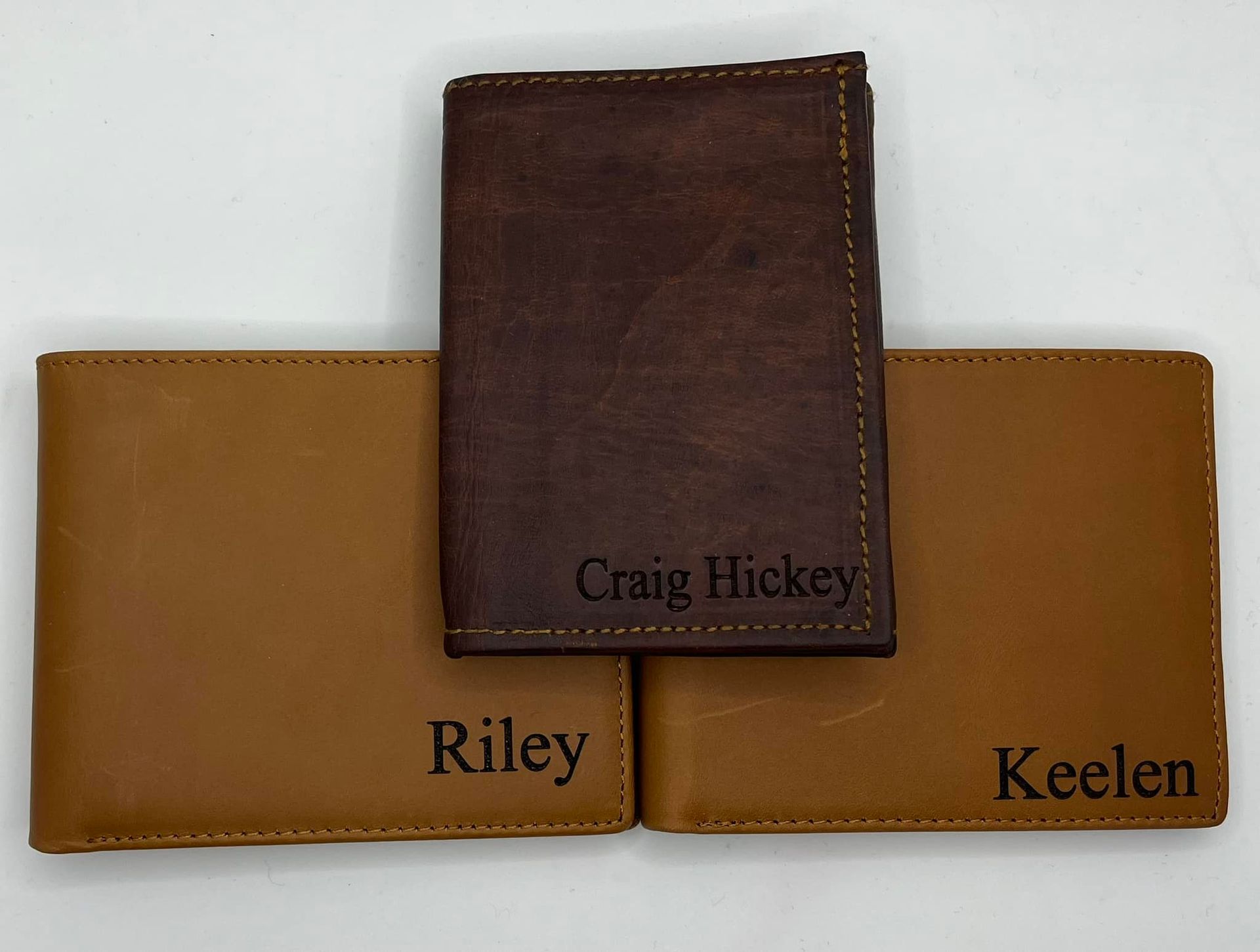 Three Wallets With the Names Riley Craig and Keelen Engraved on Them — Jimani Trophies & Engraving In Dapto, NSW
