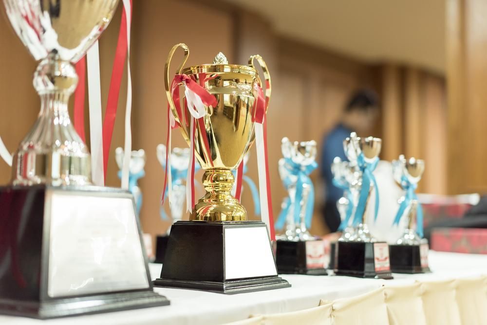 A Row of Trophies Sitting on Top of A Table — Jimani Trophies & Engraving In Dapto, NSW