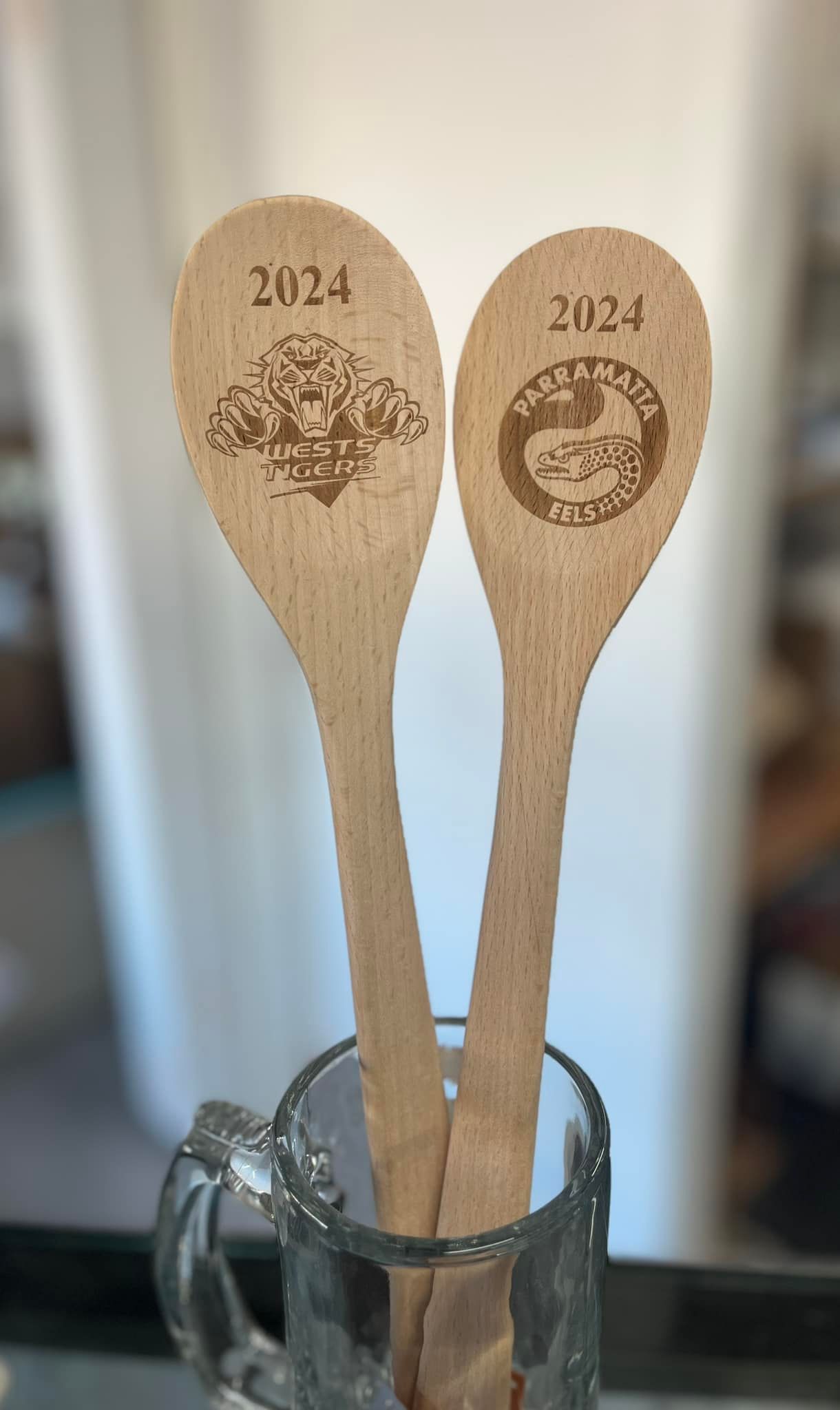 Two Wooden Spoons Are Sitting in a Glass on a Table — Jimani Trophies & Engraving In Dapto, NSW